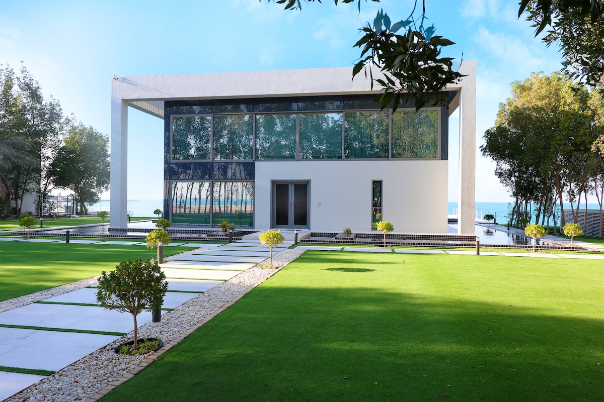 Contemporary white waterfront villa set within a manicured lawn