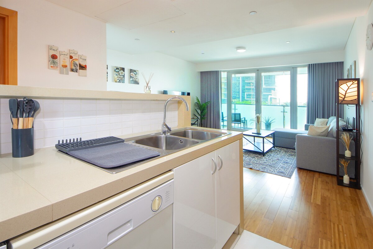 Sleek galley kitchen opening directly into the living room