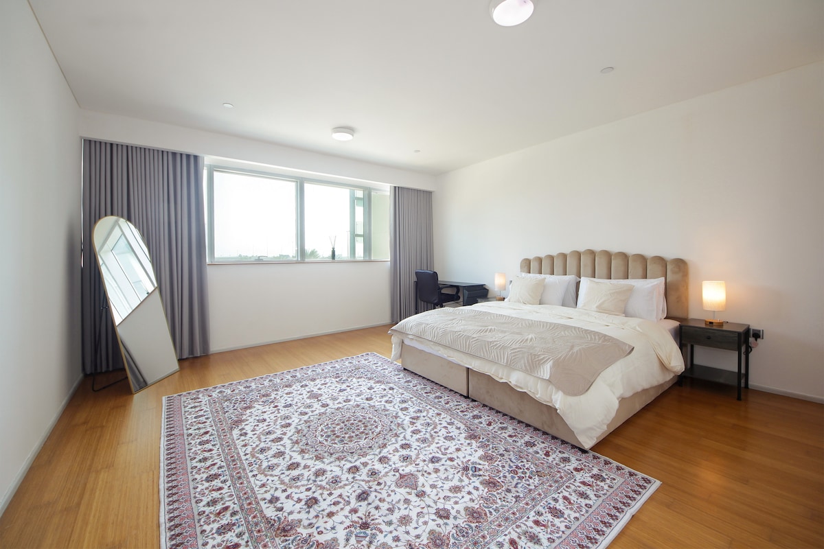 Spacious minimalist bedroom in a soft white palette